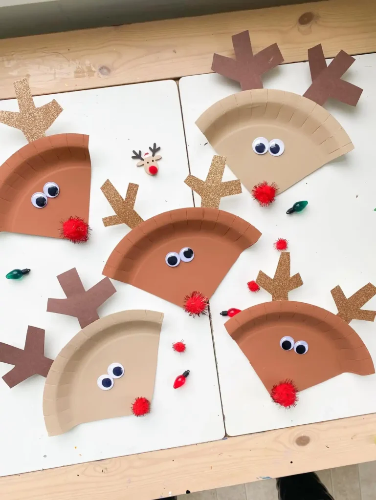 Five paper plate reindeer with googly eyes, antlers and red pom pom noses