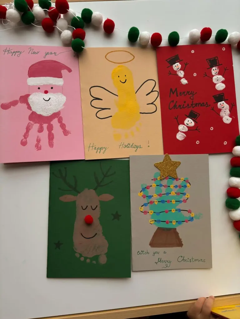 Five handprint and footprint christmas cards showing Santa, an angel, snowmen, a reindeer and a tree