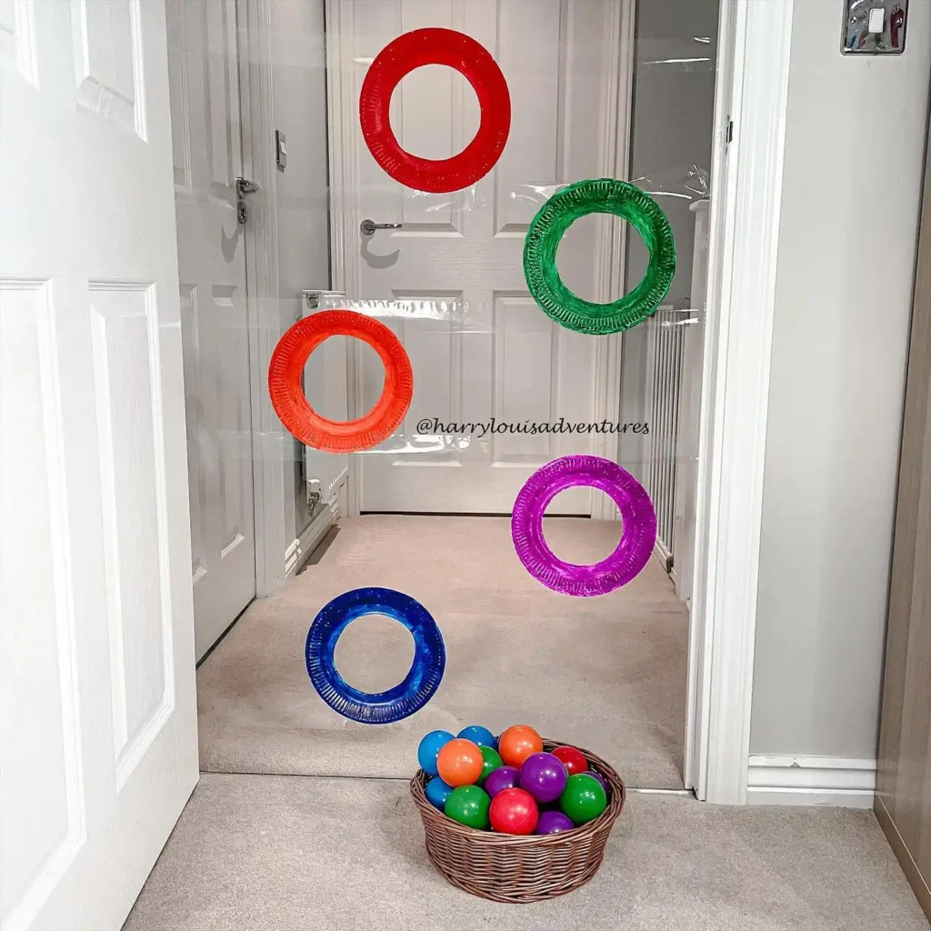 Indoor games for kids: a hallway ring toss with five painted paper plates and a basket of soft balls