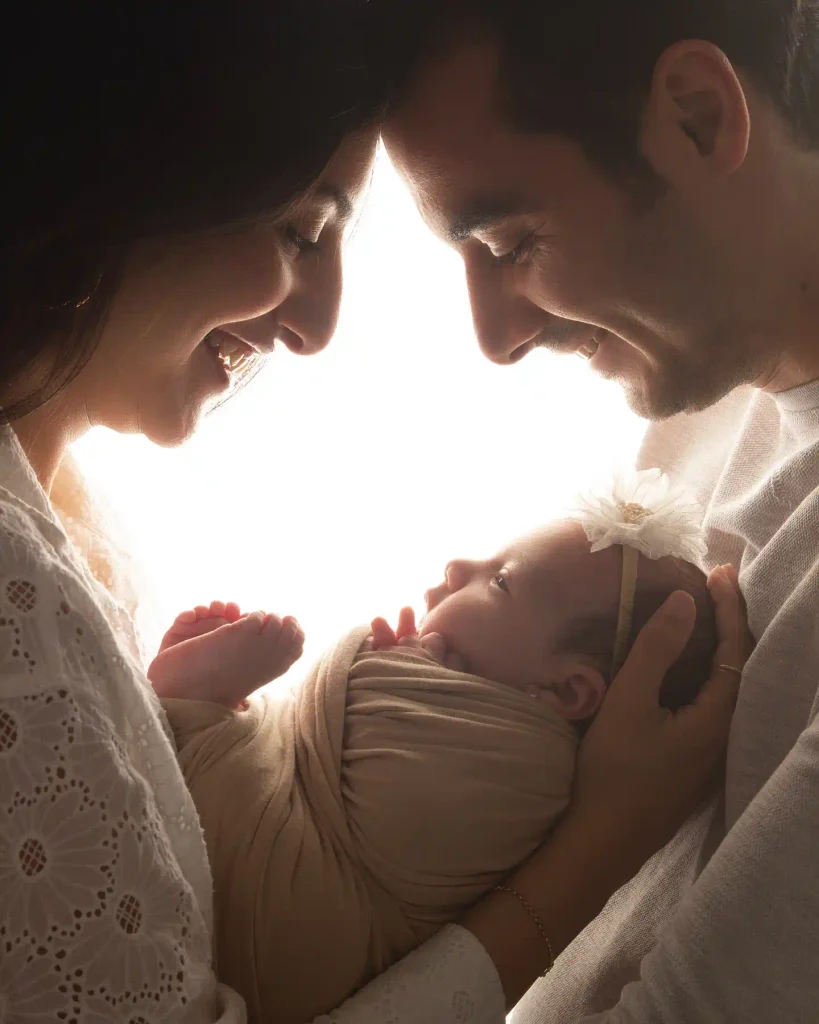 Backlit Family Silhouette With Foreheads Touching