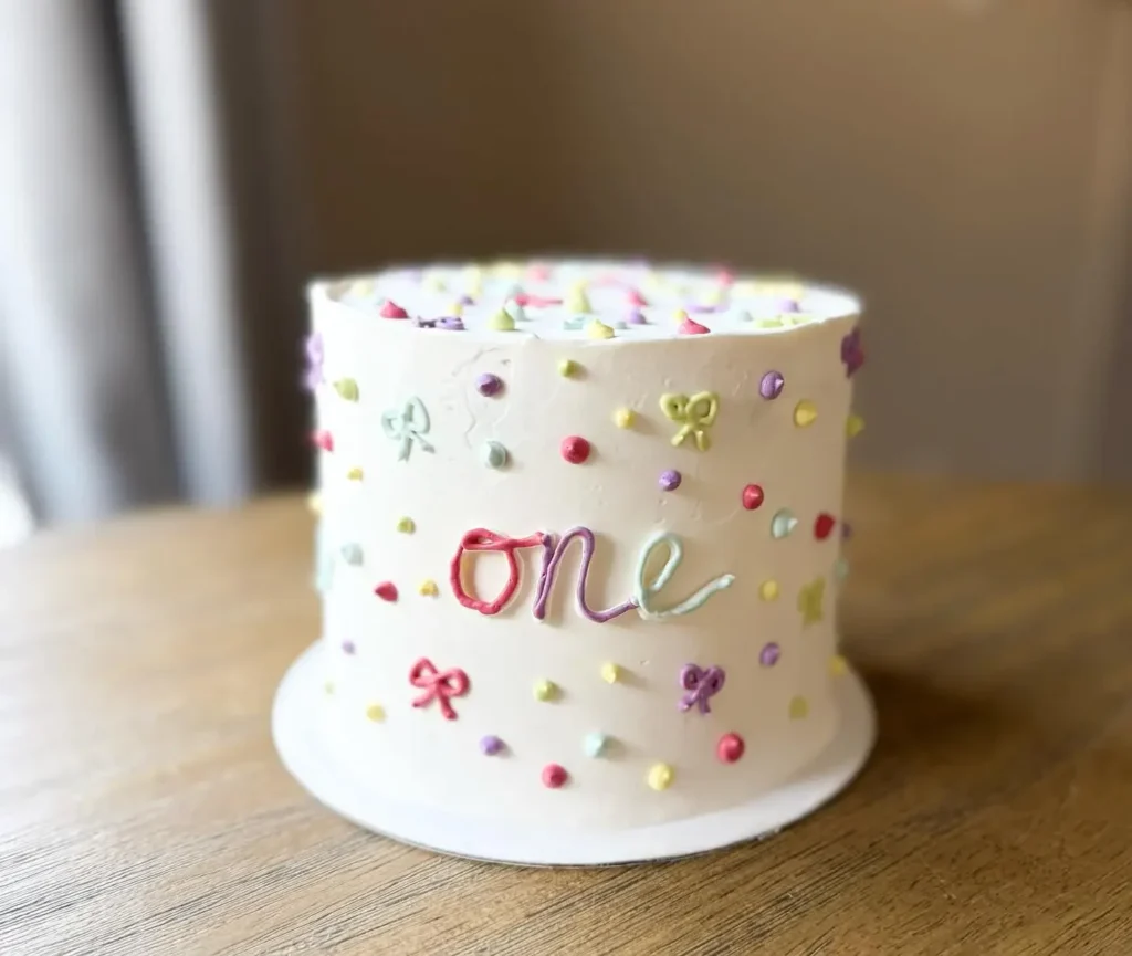 Confetti dots, tiny bows and a hand piped one on a smash cake