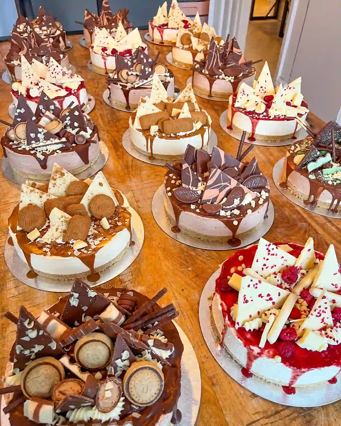 Christmas dessert boxes filled with wreath cupcakes, chocolate chip cookies, brownies, gingerbread men and gold chocolate coins beside a sliced yule log and a brownie wreath